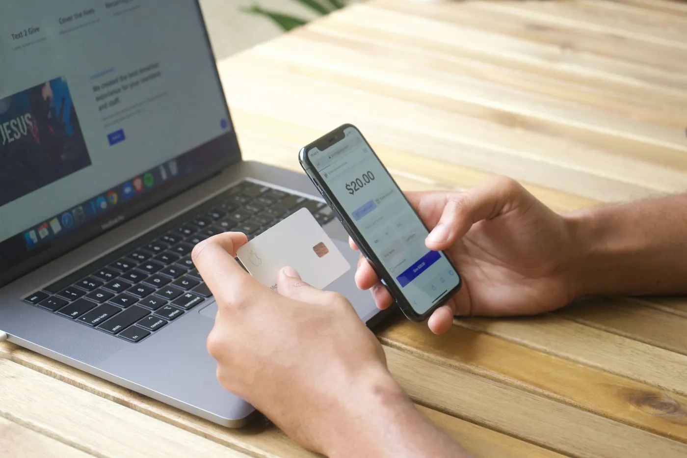 Shopper browsing an online store on a phone beside a laptop