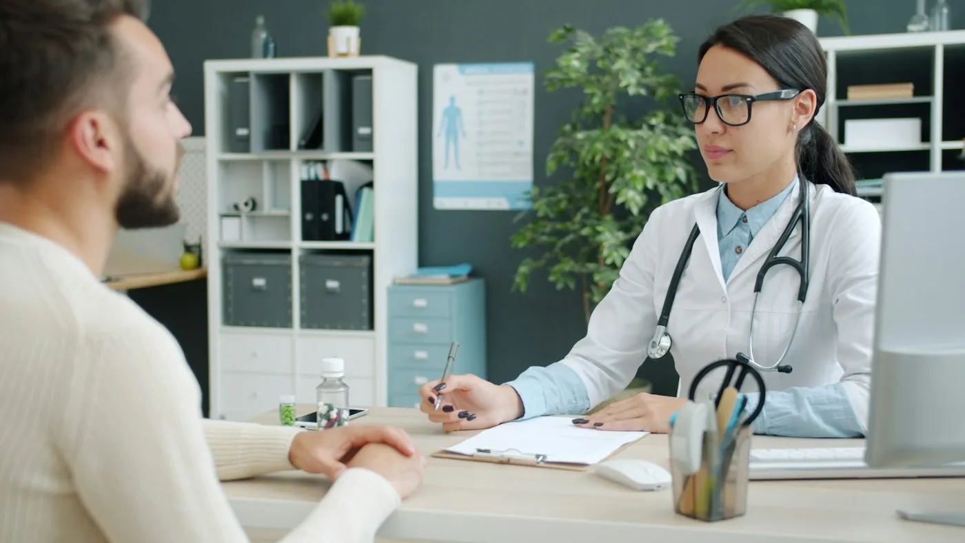 Doctor reviewing patient notes at a clinic desk