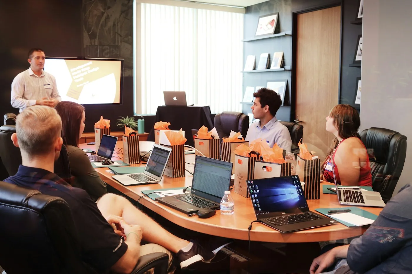 Strategist presenting a growth plan to a team working on laptops