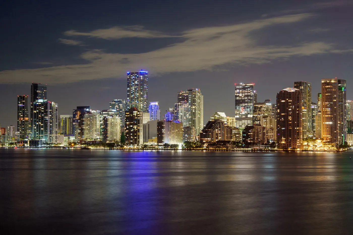 Downtown Miami skyline lit up at night across the water