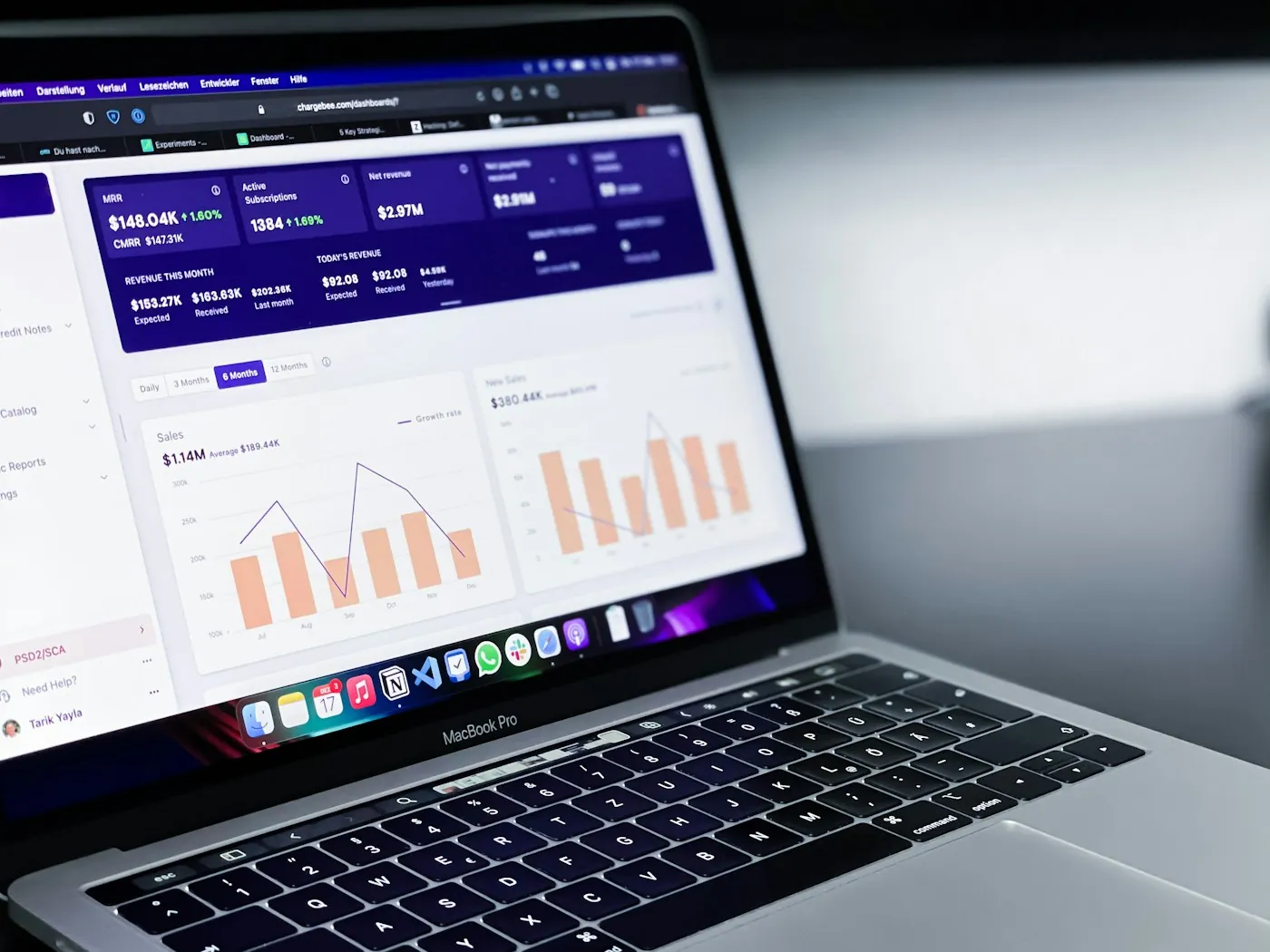Ad spend and conversion bar charts on a laptop dashboard