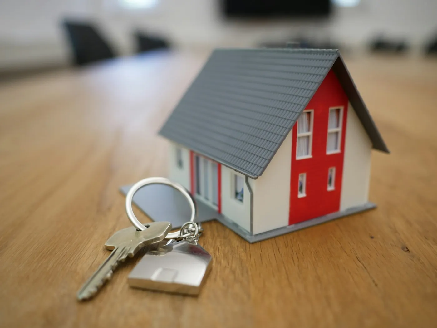 House keys beside a small model home on a desk