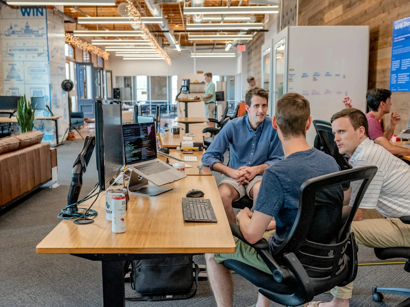 Marketing team collaborating around laptops in a bright office