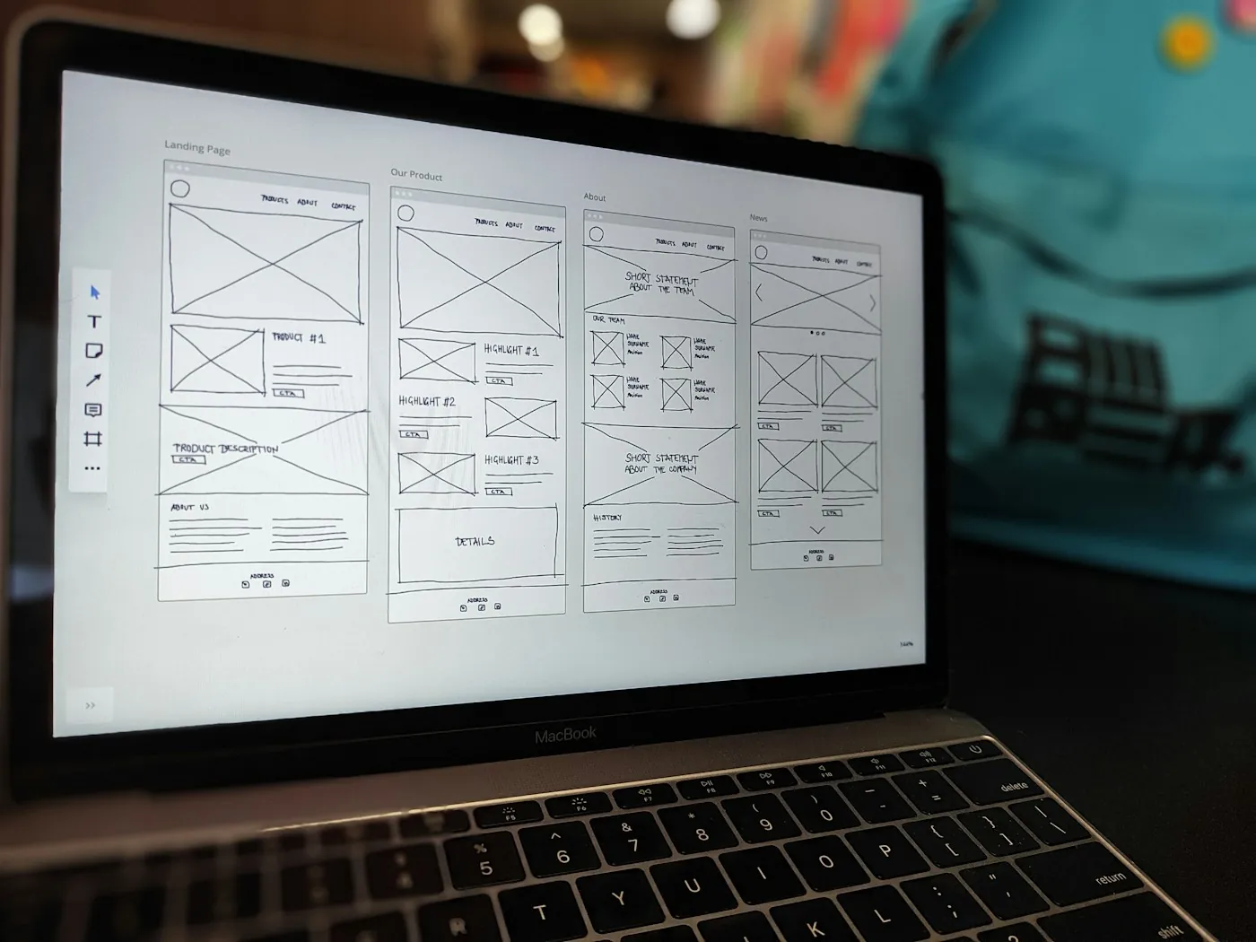 Website wireframe open on a laptop in a dark workspace